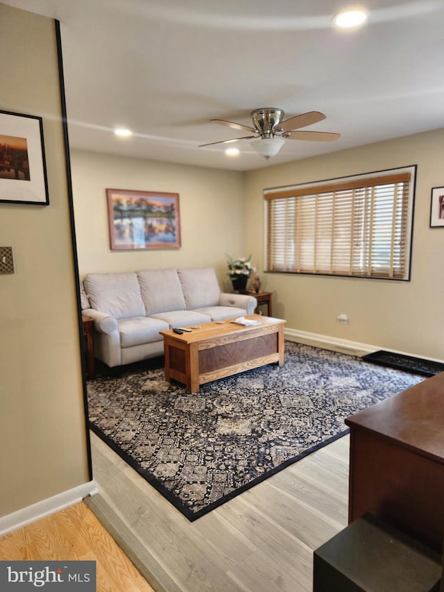 living room with wood-type flooring and ceiling fan