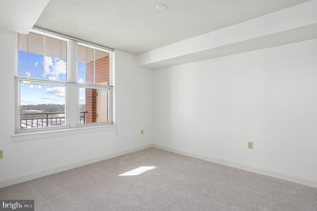 carpeted empty room with a textured ceiling