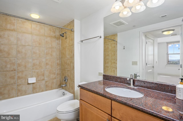 full bathroom featuring vanity, tiled shower / bath combo, and toilet