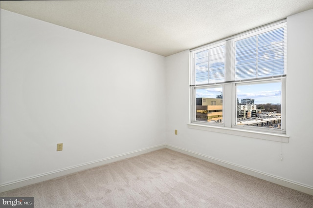 carpeted spare room with a textured ceiling