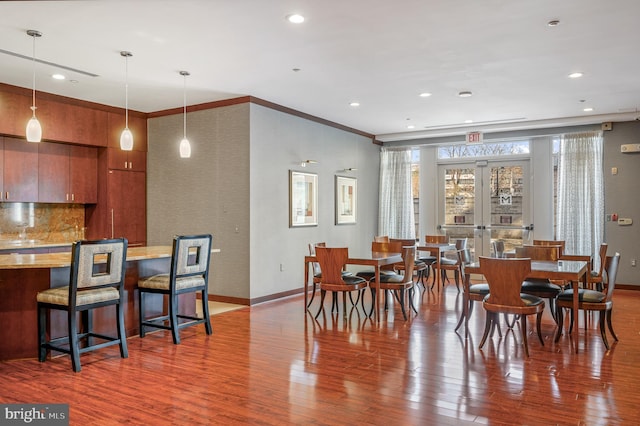 dining room featuring french doors, crown molding, and hardwood / wood-style flooring