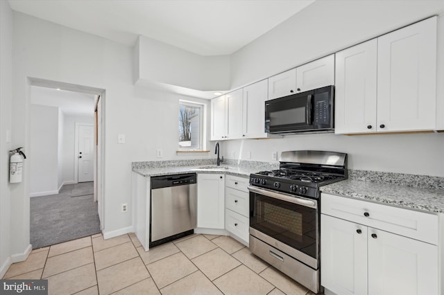 kitchen featuring stainless steel appliances, sink, light colored carpet, and white cabinets