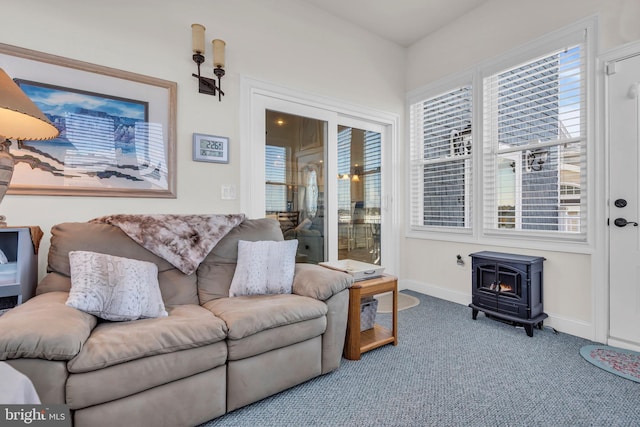 living room featuring carpet and a wood stove