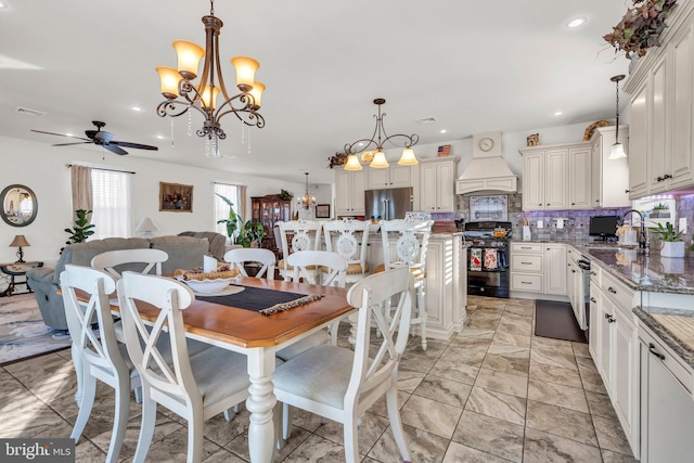 dining room featuring ceiling fan with notable chandelier and sink