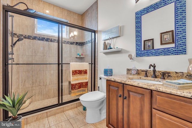 bathroom featuring vanity, toilet, tile patterned flooring, and a shower with door