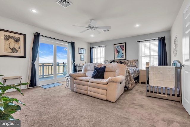 bedroom with light colored carpet, multiple windows, and access to outside