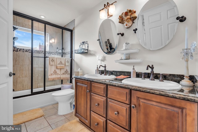 full bathroom featuring vanity, bath / shower combo with glass door, tile patterned floors, and toilet