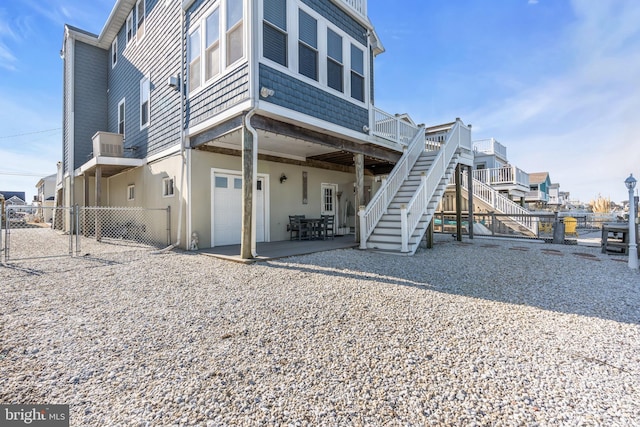 back of property featuring a garage and a patio