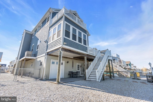 rear view of property with a garage and a patio