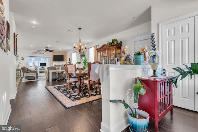 dining space with dark hardwood / wood-style floors and ceiling fan with notable chandelier