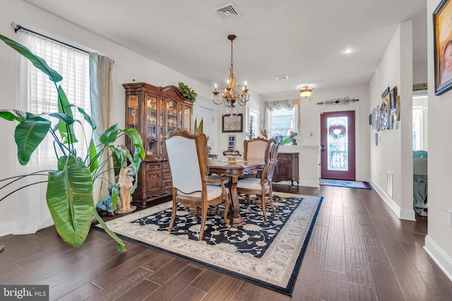 dining space featuring an inviting chandelier and dark hardwood / wood-style flooring