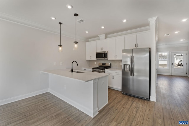 kitchen with pendant lighting, appliances with stainless steel finishes, sink, and white cabinets