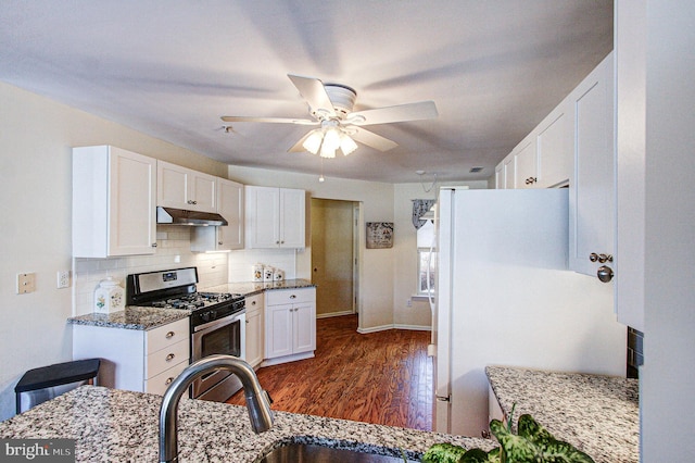 kitchen featuring dark hardwood / wood-style floors, white cabinetry, decorative backsplash, dark stone counters, and gas stove