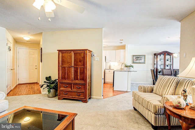 living room with light carpet, sink, and ceiling fan