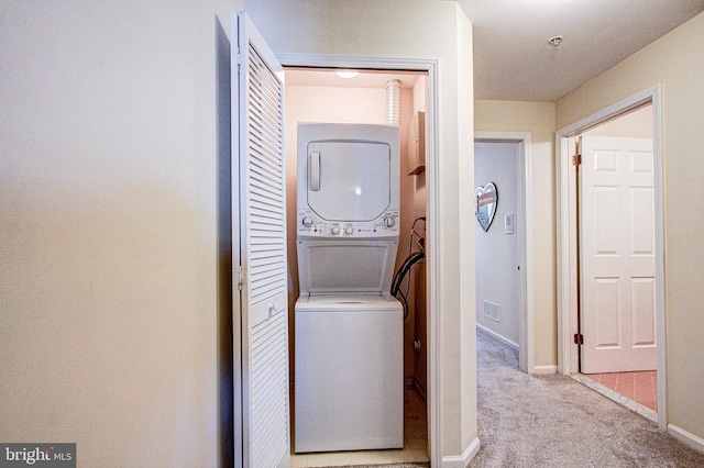 laundry area with light carpet and stacked washing maching and dryer