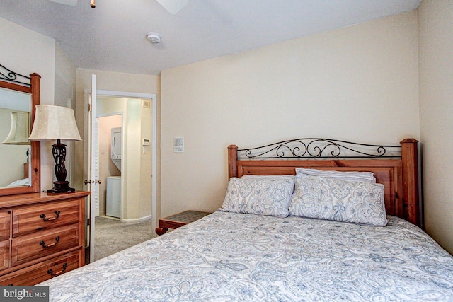 carpeted bedroom featuring stacked washer and dryer