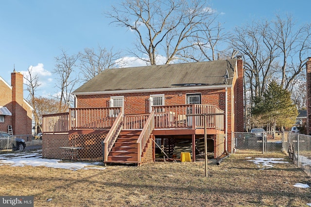 rear view of property with a deck and a lawn