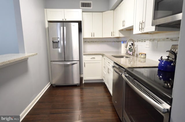 kitchen featuring white cabinetry, sink, backsplash, stainless steel appliances, and light stone countertops