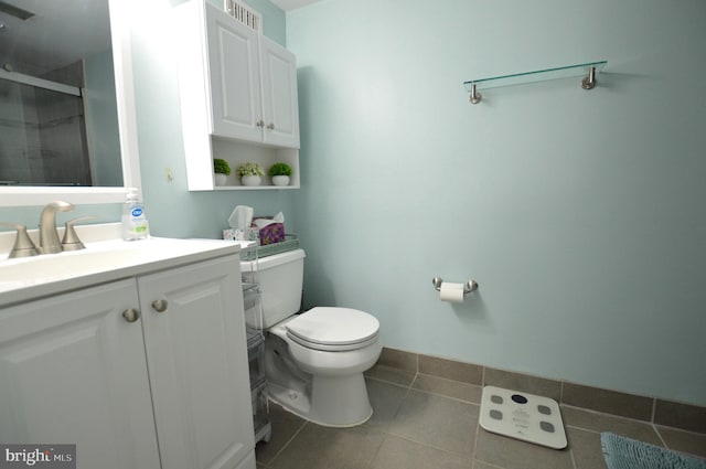 bathroom with vanity, a shower with shower door, tile patterned floors, and toilet