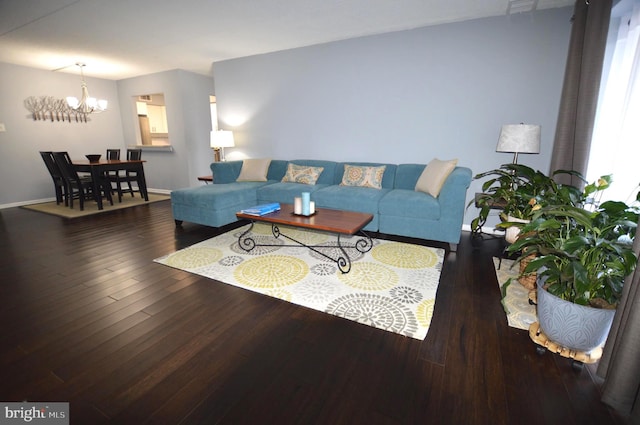 living room with dark hardwood / wood-style floors and a chandelier