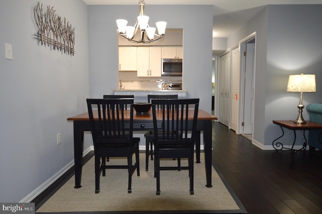 dining area with dark hardwood / wood-style floors and a chandelier