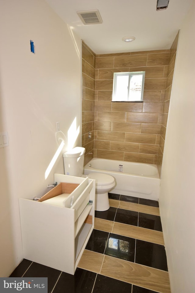 full bathroom with tile patterned floors, toilet, tiled shower / bath combo, and vanity