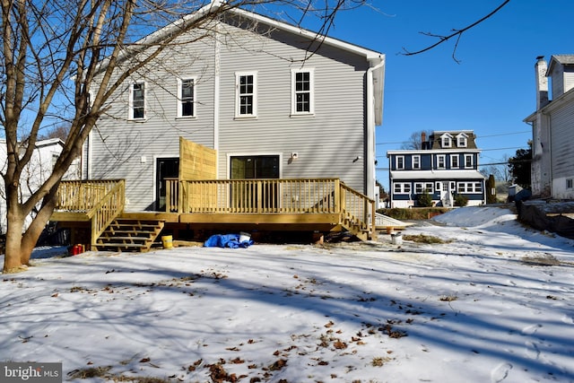 snow covered property with a wooden deck