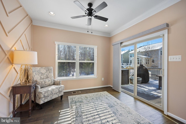 sitting room with ceiling fan, crown molding, dark hardwood / wood-style floors, and a healthy amount of sunlight