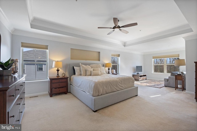 bedroom featuring light colored carpet, ornamental molding, a raised ceiling, and ceiling fan