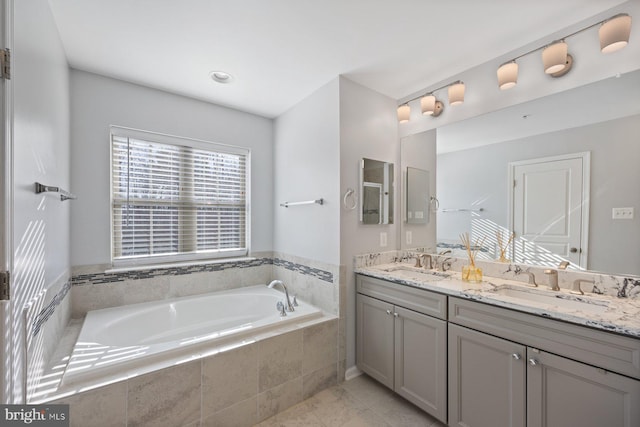 bathroom with tiled tub and vanity