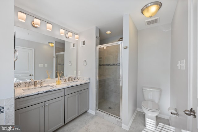 bathroom with vanity, a shower with door, and toilet