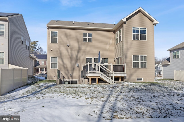 snow covered house with a wooden deck