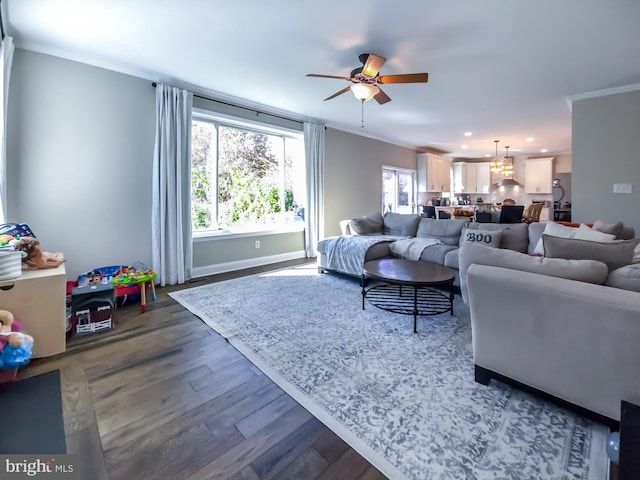 living room with dark wood-type flooring, ornamental molding, and a healthy amount of sunlight