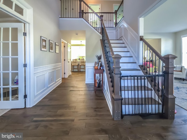 stairway featuring hardwood / wood-style flooring and a high ceiling