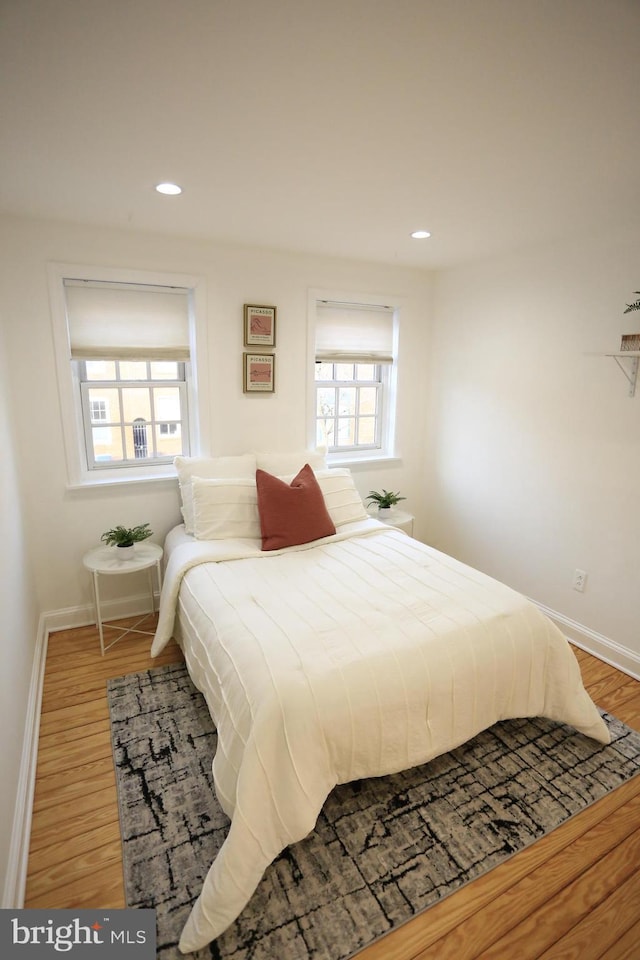 bedroom featuring hardwood / wood-style floors and multiple windows