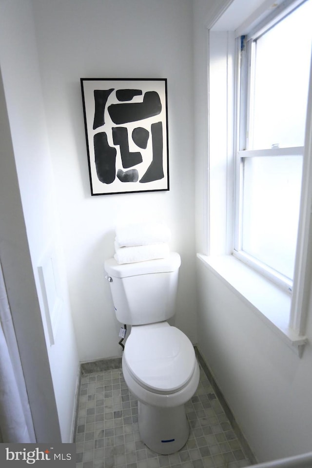 bathroom with plenty of natural light and toilet