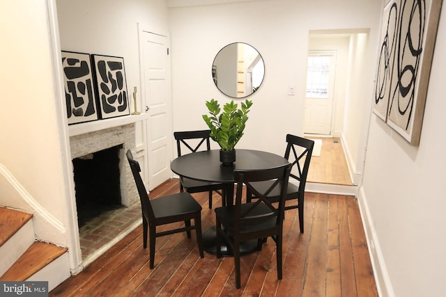 dining space with a fireplace and dark hardwood / wood-style flooring