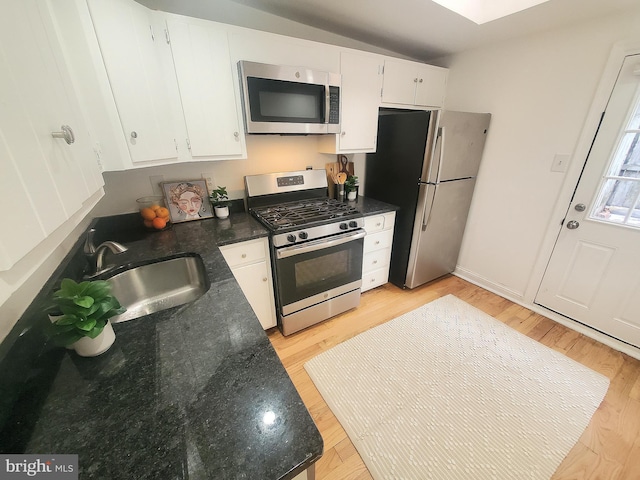 kitchen featuring white cabinetry, appliances with stainless steel finishes, sink, and light wood-type flooring