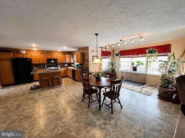 dining space with a textured ceiling and light floors