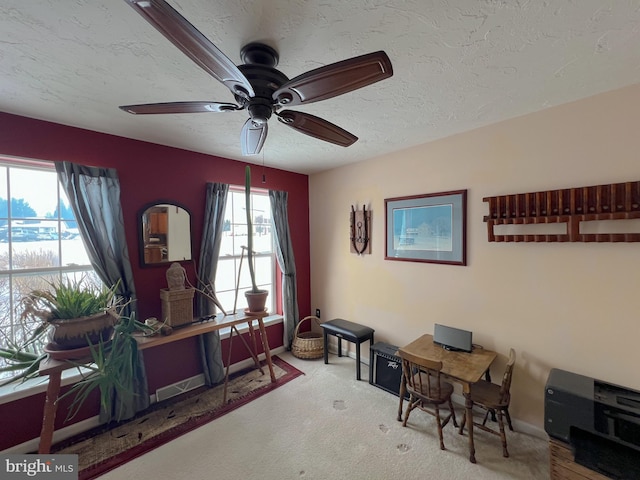 carpeted office with ceiling fan and a textured ceiling