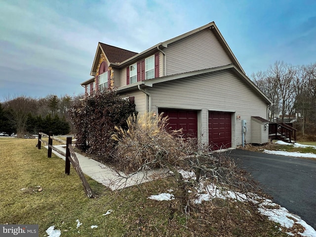 view of home's exterior with aphalt driveway, a lawn, and an attached garage