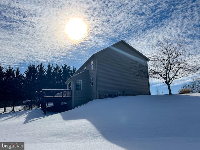 view of snowy exterior featuring a wooden deck