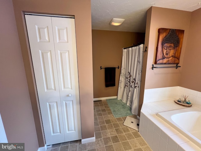 bathroom with curtained shower, a closet, a textured ceiling, and a bath