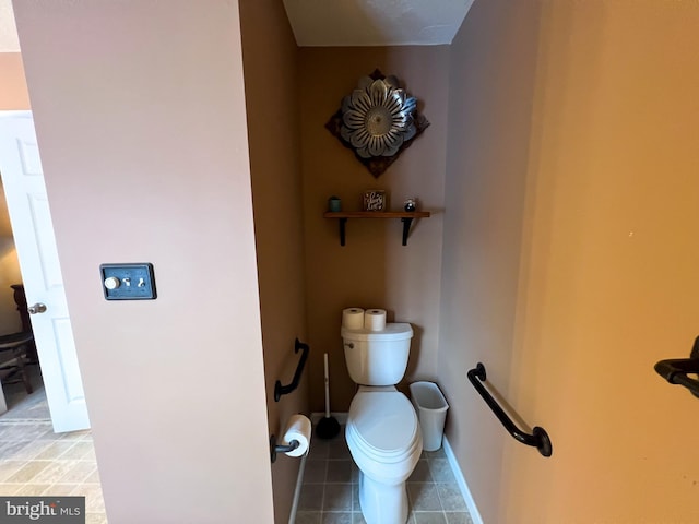 bathroom featuring baseboards, toilet, and tile patterned floors