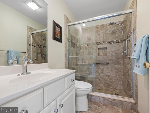 bathroom with vanity, a shower with shower door, and toilet