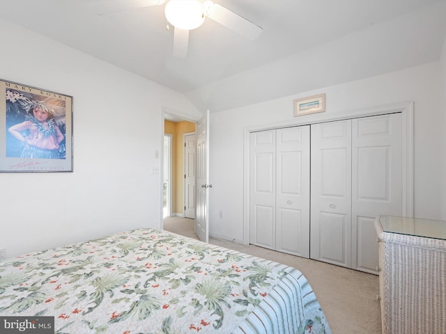 bedroom with ceiling fan, a closet, lofted ceiling, and light carpet