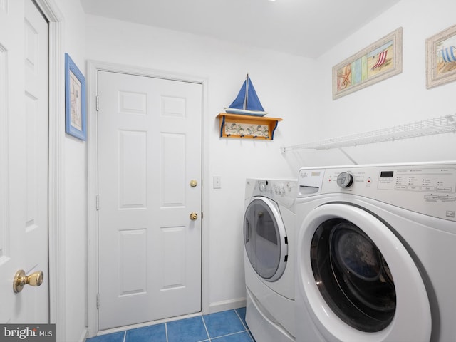 clothes washing area with tile patterned floors and washer and clothes dryer