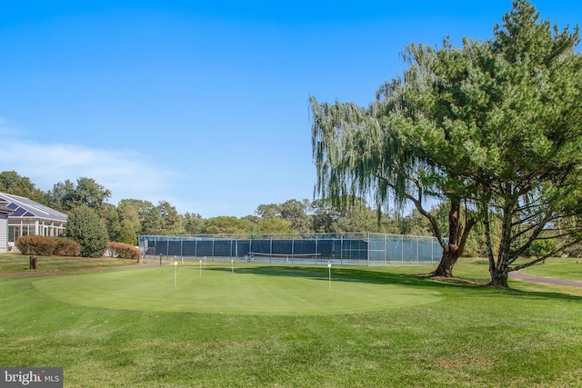 view of tennis court featuring a yard