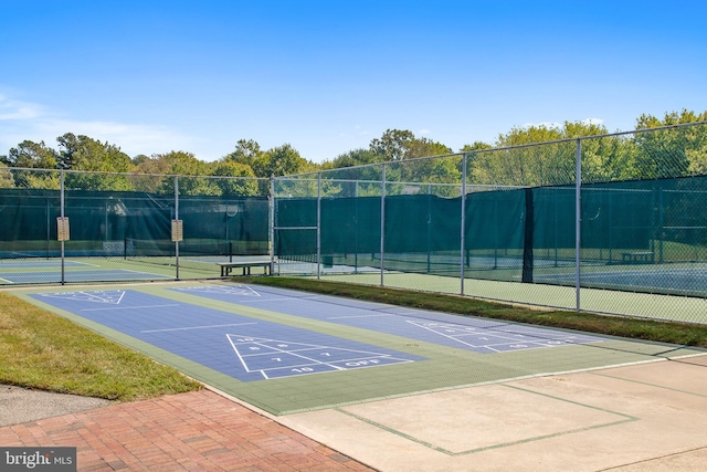 view of home's community featuring tennis court