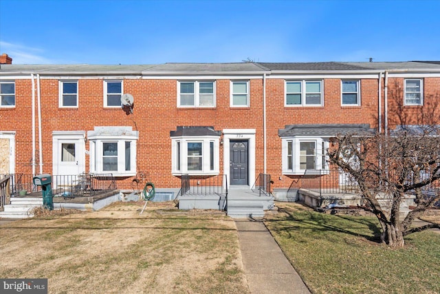 townhome / multi-family property with a front lawn